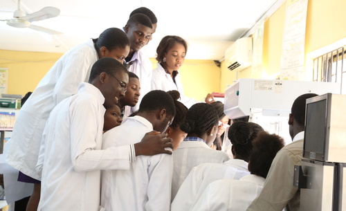 A group of scientists wearing lab coats in a lab at ACEGID.