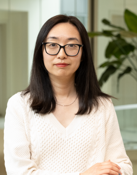 Gail Guo is facing the camera in the Broad Institute building in front of a hallway.